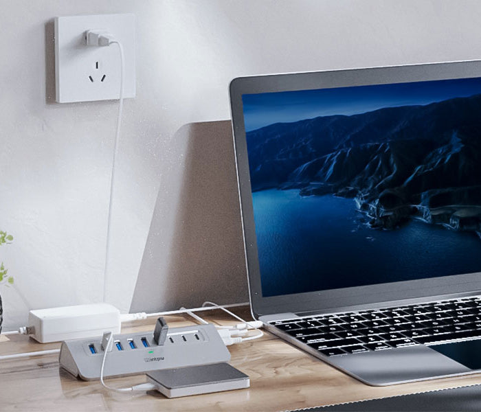 a silver intpw yh6ac connect laptop on a desk with a plant.