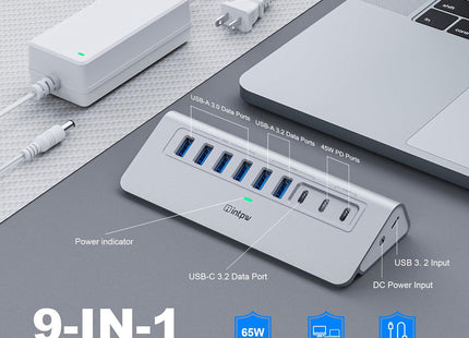 a silver intpw yh6ac usb hub and a laptop on the desk.